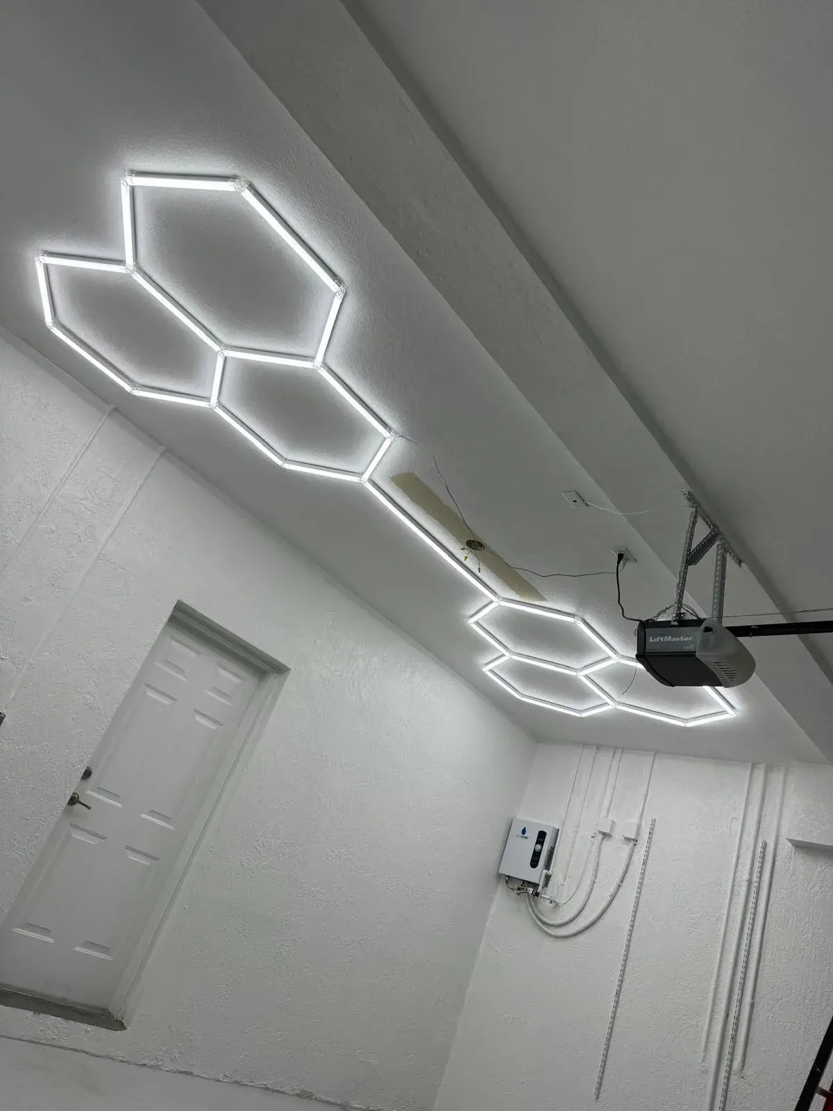 White garage with lit hexagon-shaped LED light bars on the ceiling